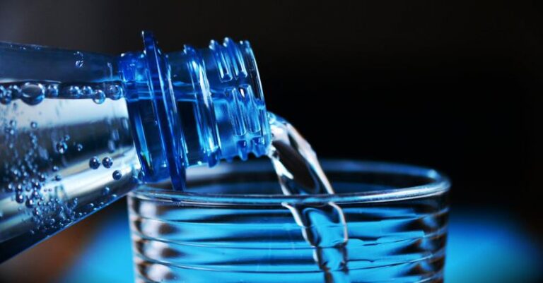 Hydration - Close-up of Bottle Pouring Water on Glass