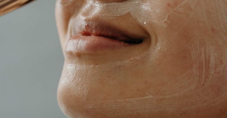 Exfoliation - A Close-up Shot of a Woman Applying a Cream on Her Face