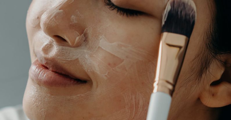 Exfoliation - A Woman Applying a Cream on Her Face with Her Eyes Closed