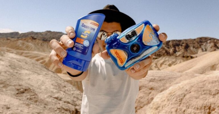 Sunscreen - Man Holding Blue Kodak Camera and Sunscreen