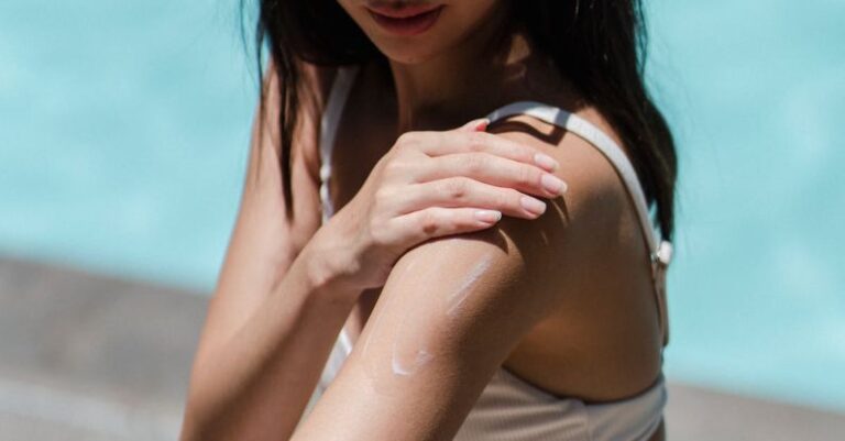 Sunscreens - From above of female wearing sunglasses and bikini relaxing on deckchair on poolside at resort