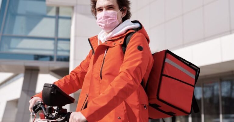 Masks - Delivery Man Wearing a Face Mask and Riding a Bicycle